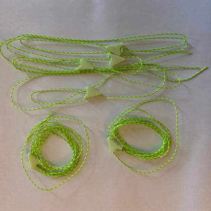 A set of neon green guyline chords for tents or tarps with individual tensioners set out on a white background 