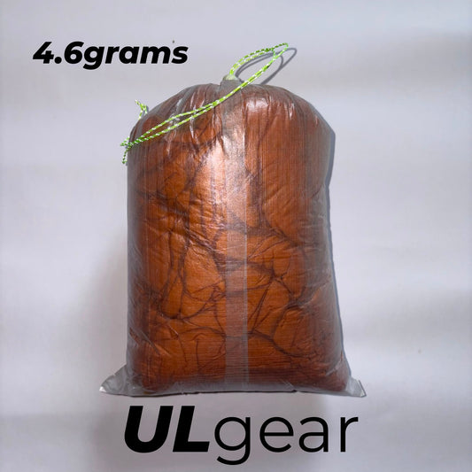 White DCF Dyneema stuff sack with orange stitching and glow in the dark cord lock
